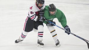 Ishockeyspelare i närkamp om pucken på isen under en hockeymatch