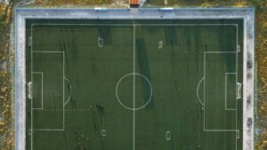 Flygbild rakt uppifrån över en fotbollsplan som visar mått, mittlinje, mittcirkel och straffområden