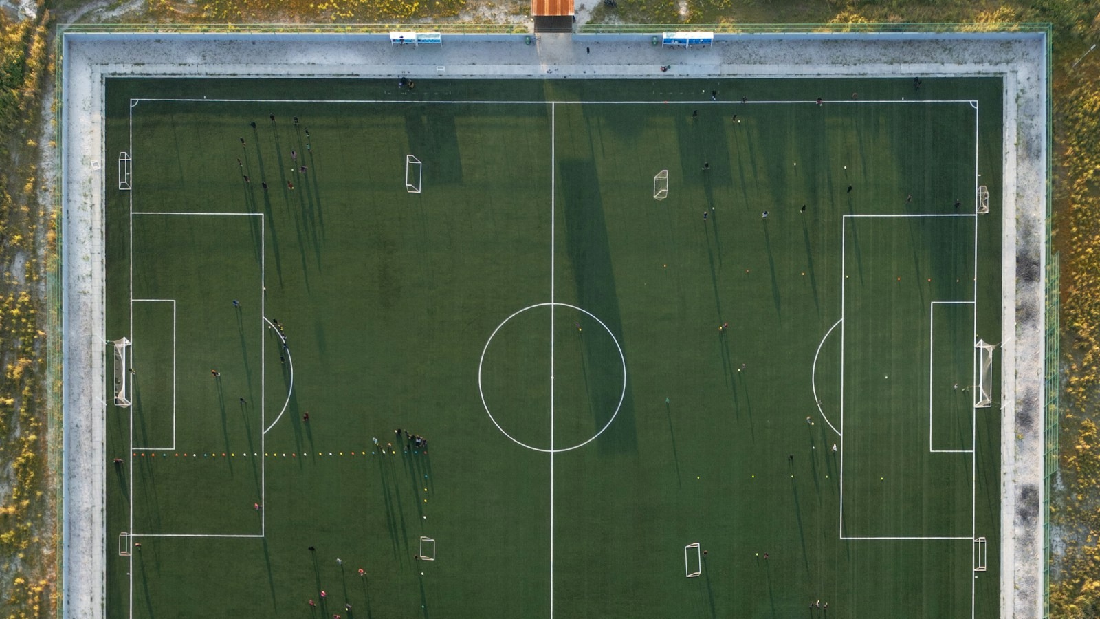 Flygbild rakt uppifrån över en fotbollsplan som visar mått, mittlinje, mittcirkel och straffområden